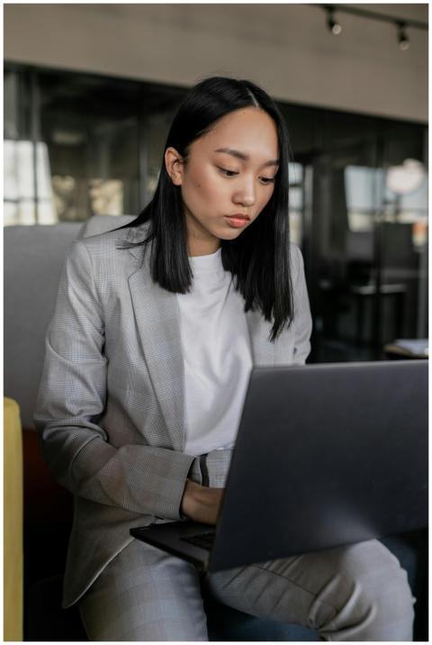 Focused Asian woman in business attire working on