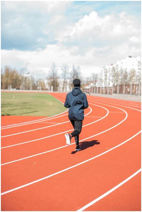 A woman runner exercising on a track outdoors duri