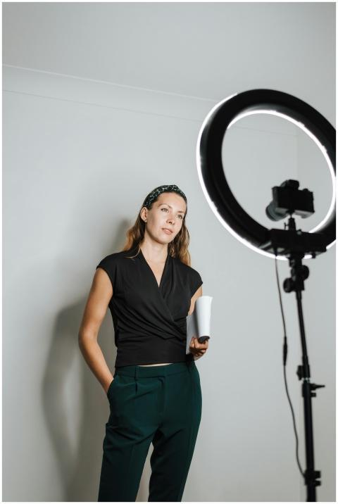 Young woman with ring light and camera in a studio