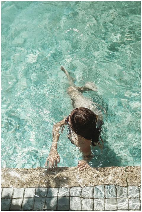 A person enjoying a sunny day swimming in a clear