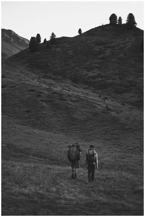 Two hikers traverse a serene mountain path in Cesa