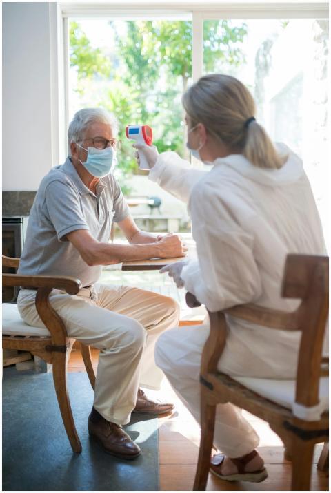 A healthcare worker uses a digital thermometer on