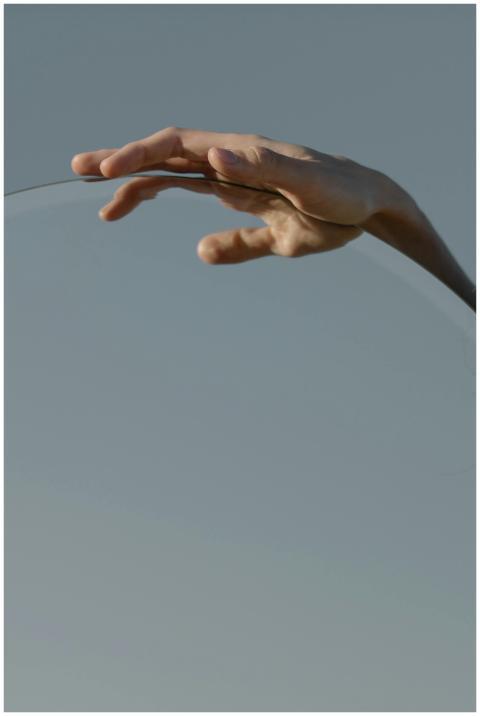 A conceptual image of a hand reflecting over a mir