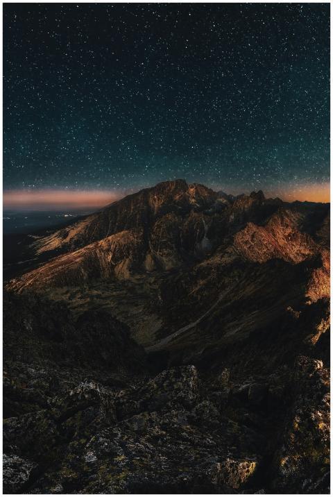 Stunning starry night sky over rugged mountains, p
