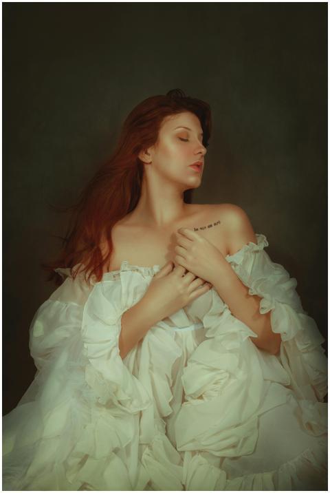 Elegant portrait of a woman with red hair in a whi