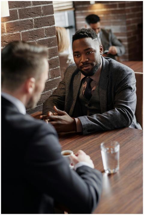 Two businessmen in suits chatting during a coffee