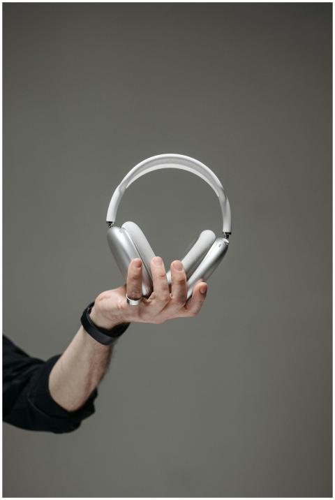 Close-up of a hand holding sleek wireless headphon