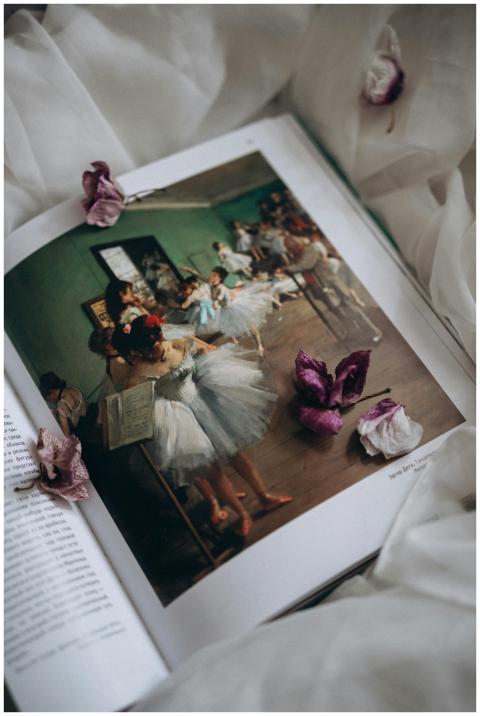 Open book showcasing ballet art surrounded by deli