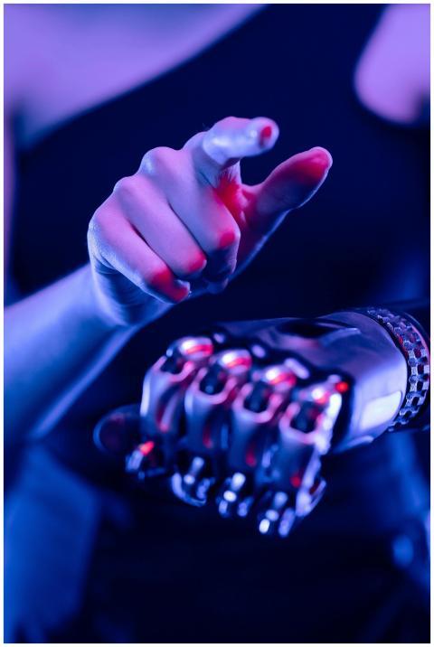 Close-up of a prosthetic arm in blue and pink neon