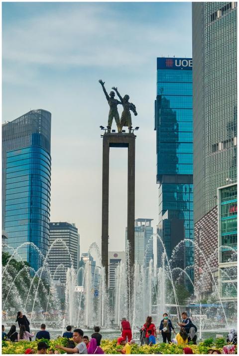 Famous statue surrounded by skyscrapers and founta