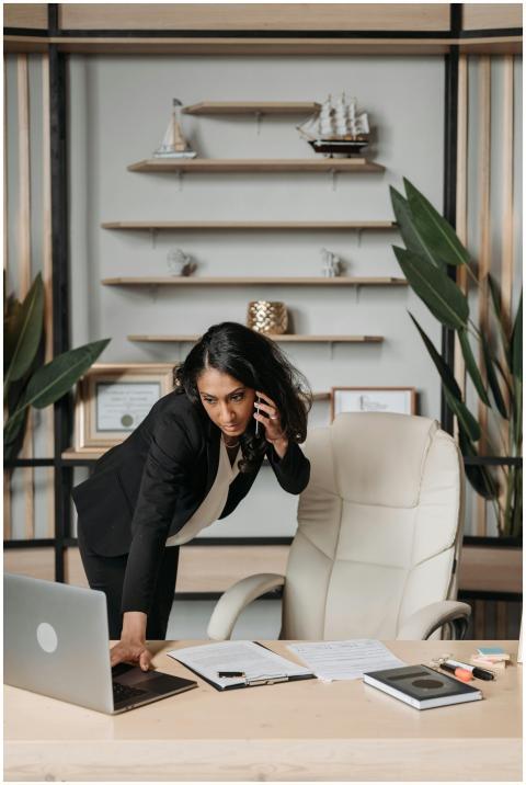Professional woman in office multitasking with lap