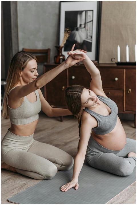 Pregnant woman doing yoga at home with support fro