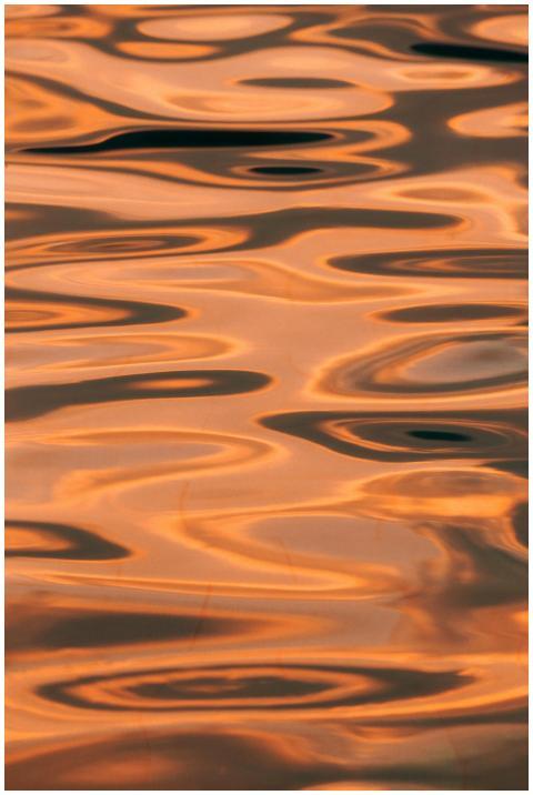 Abstract golden hues reflected on a tranquil water