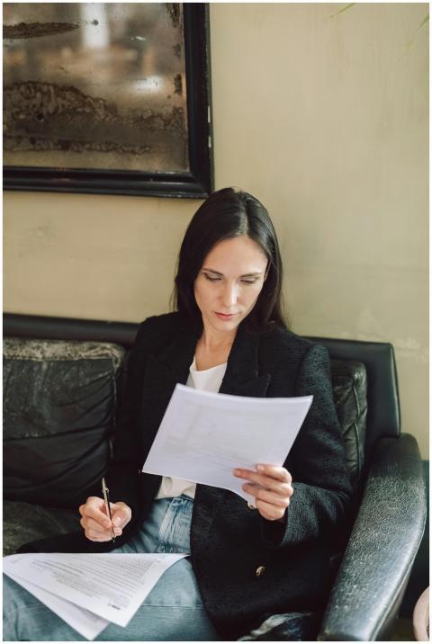 Businesswoman in black blazer analyzing paperwork