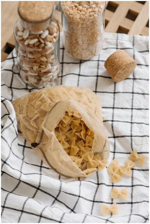 Open eco-friendly bag with uncooked farfalle pasta