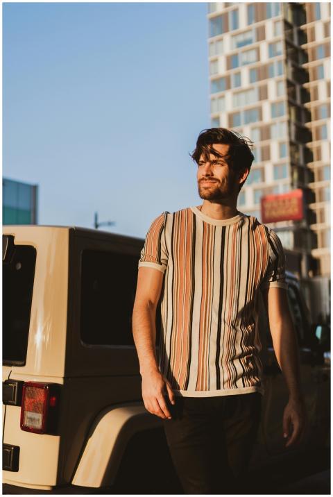 Casual urban fashion portrait of a man walking in