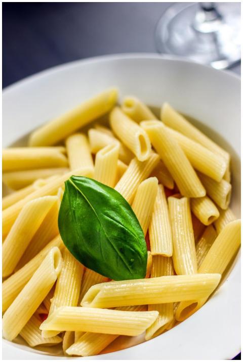Close-up of savory penne pasta with a fresh basil