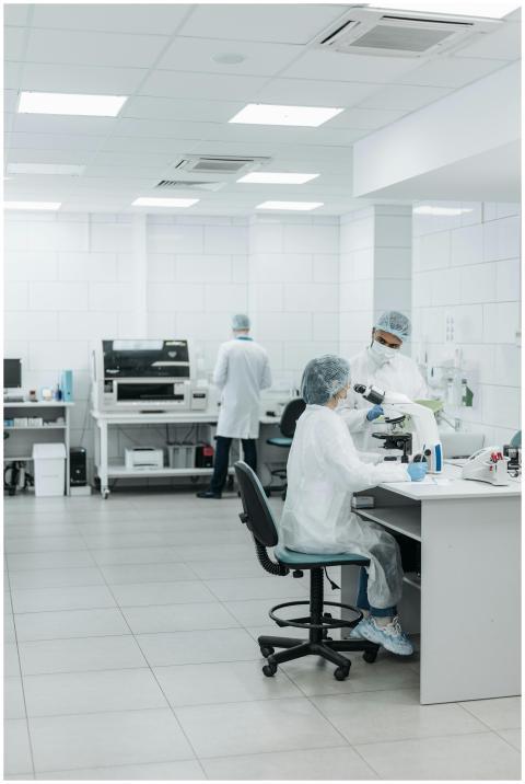 Scientists in protective suits working with micros