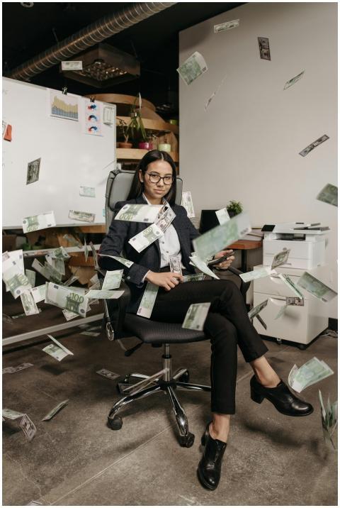 Businesswoman in modern office with falling cash,