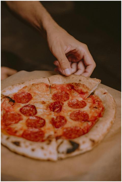 Close-up of a hand holding a slice of delicious pe