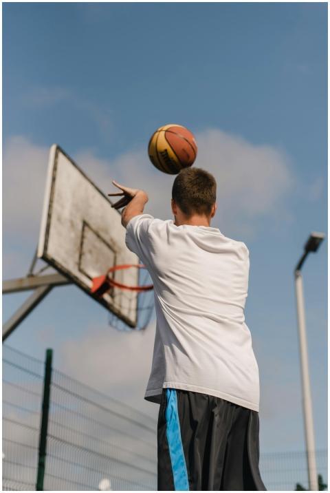 Back view of a young man making a basketball shot