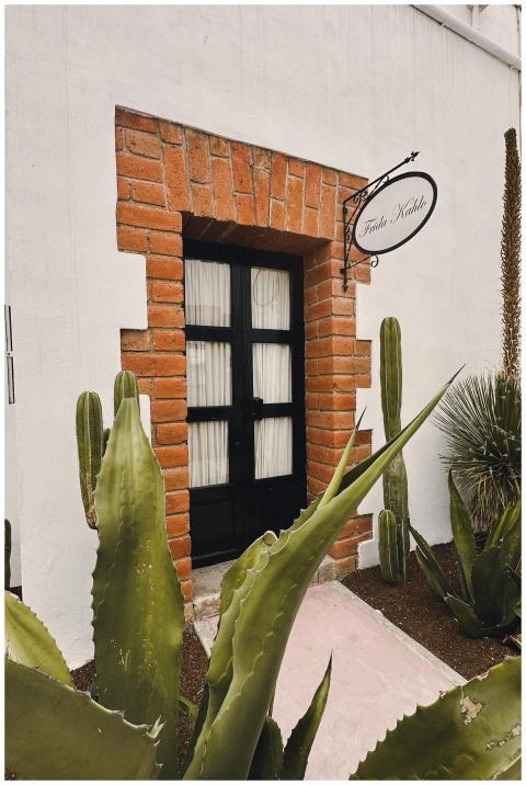 A rustic doorway framed by red bricks and desert p
