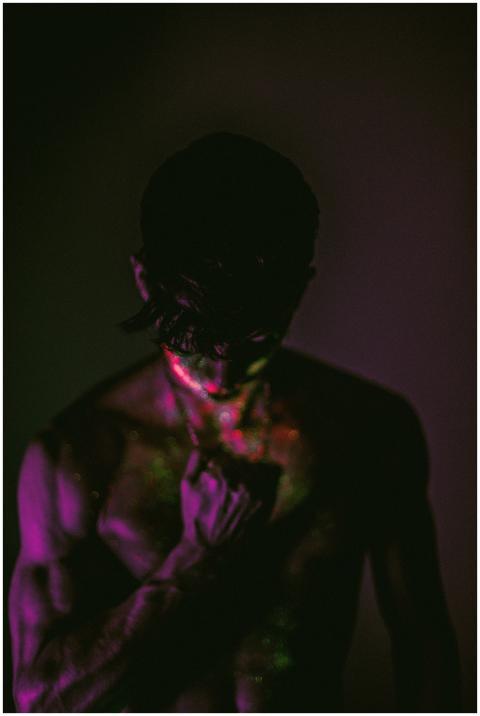 A dramatic portrait of a shirtless man illuminated