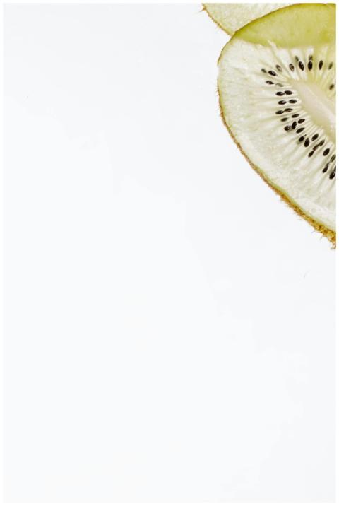 A fresh sliced kiwi on white surface with ample co