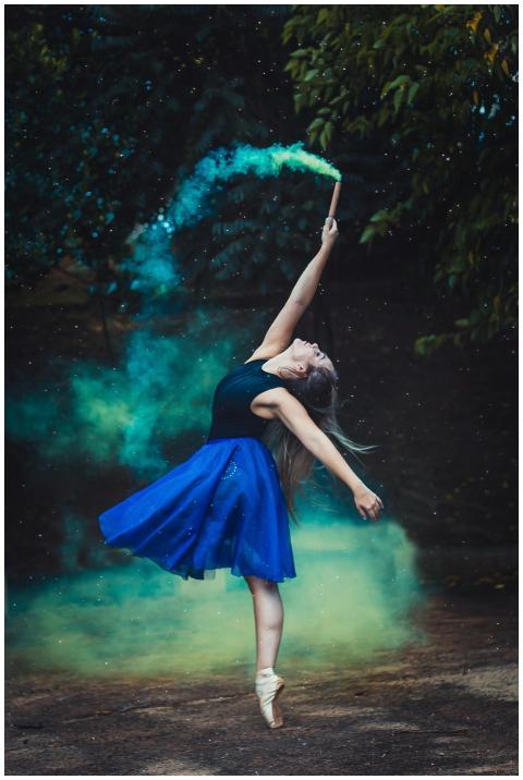 A graceful ballerina in a blue dress performs an e