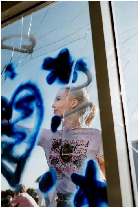 A creative artist painting blue graffiti on a wind