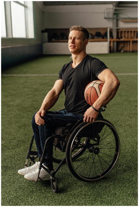 Motivated wheelchair basketball player holding bal