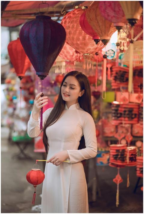 Woman dressed in traditional attire holding lanter