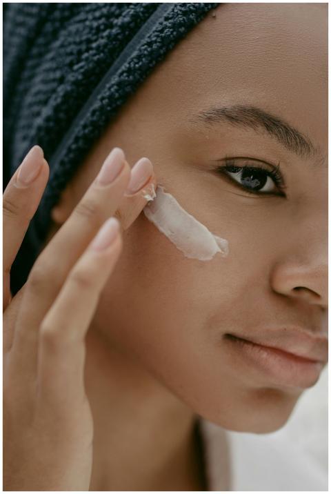 A woman gently applies moisturizing cream to her c