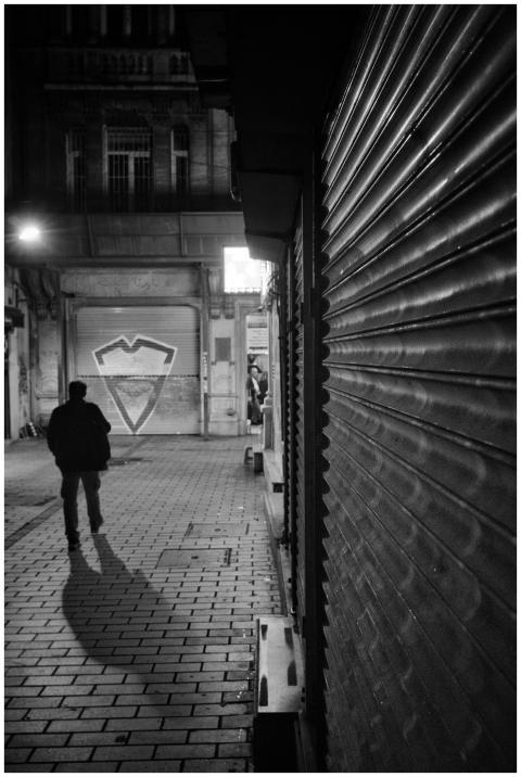 Silhouette of a person walking down a dimly lit ur