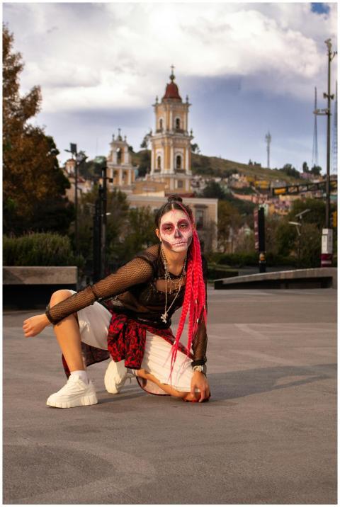 Young woman with Day of the Dead makeup poses in f