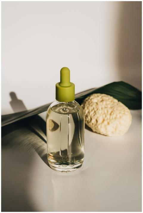 A chic skincare bottle alongside a sponge and gree