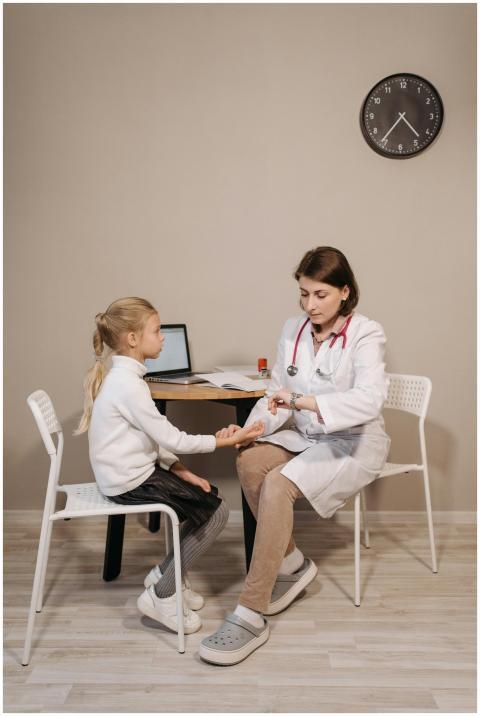 A pediatrician consults a young girl in a clinic s