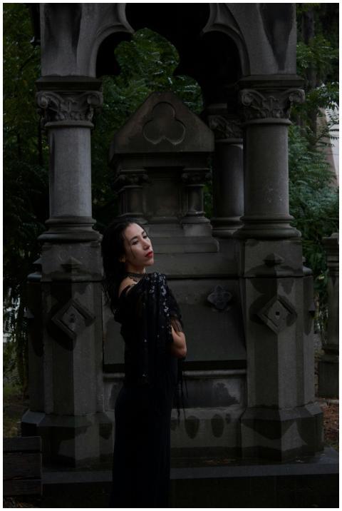 Elegant woman in black by a gothic mausoleum creat