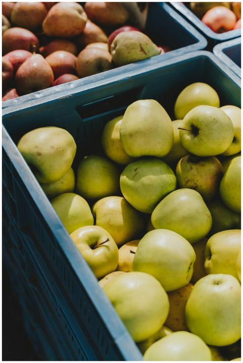 Vibrant green apples displayed in colorful crates