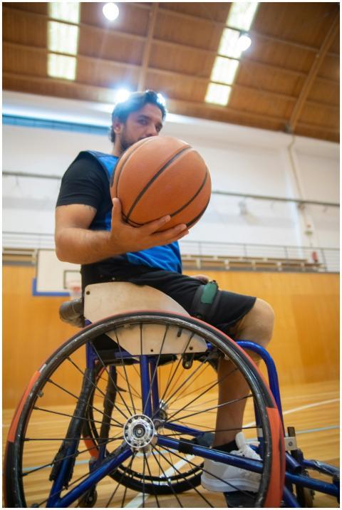 Adaptive basketball player in a wheelchair practic