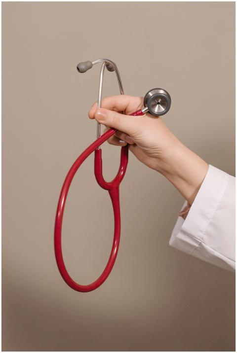 A close-up shot of a hand holding a red stethoscop