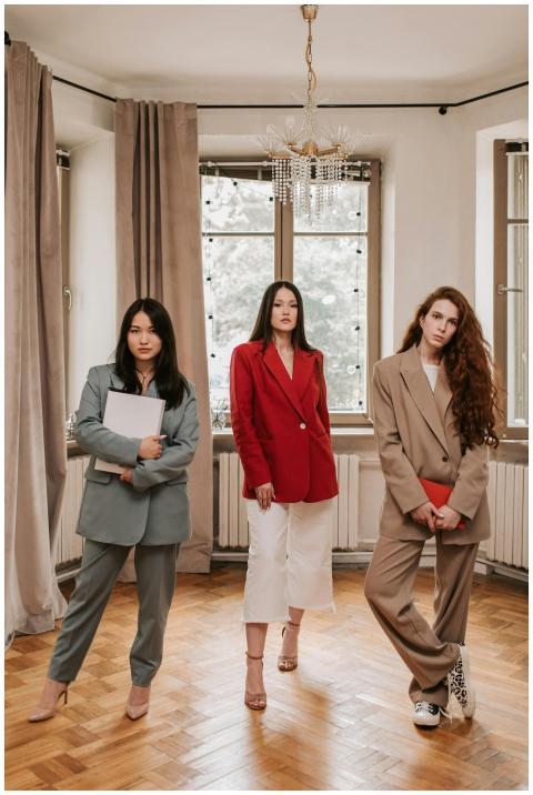 Three confident women in business attire represent