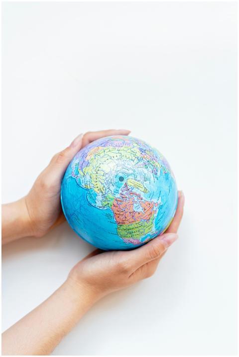 A close-up of hands gently holding a colorful glob