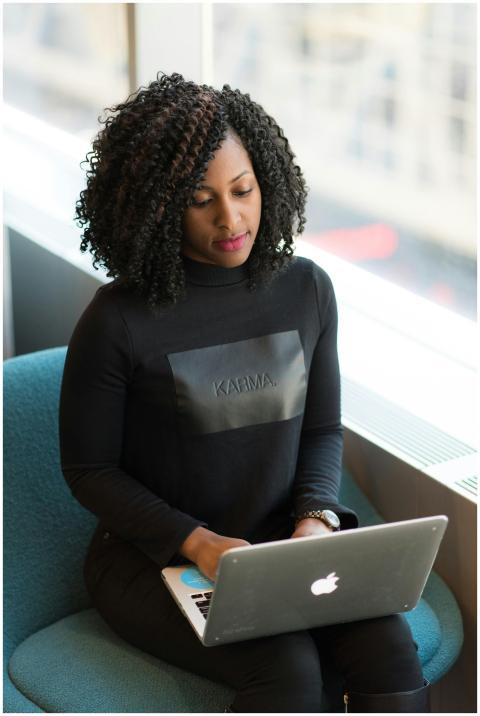Confident woman using a laptop in a bright office