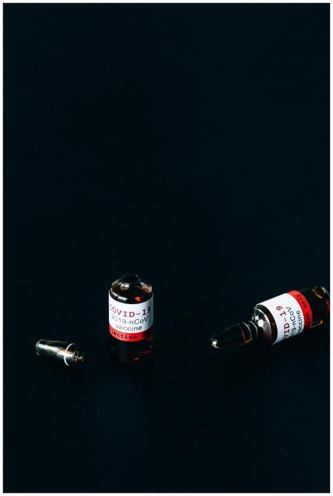Close-up of COVID-19 vaccine vials on a dark backg