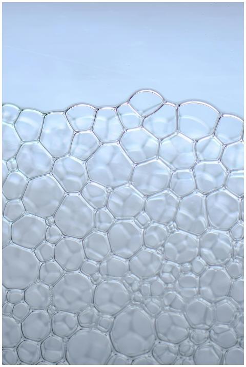 Intricate soap bubbles against a light blue backgr