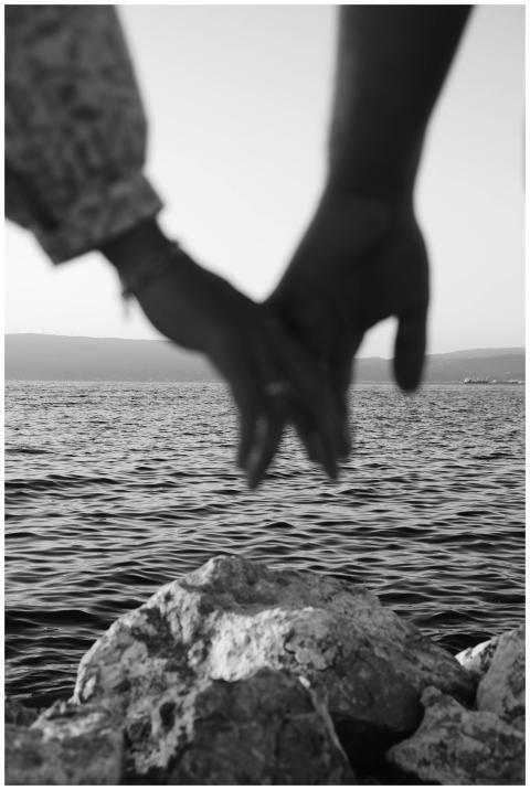 A black and white image of a couple holding hands