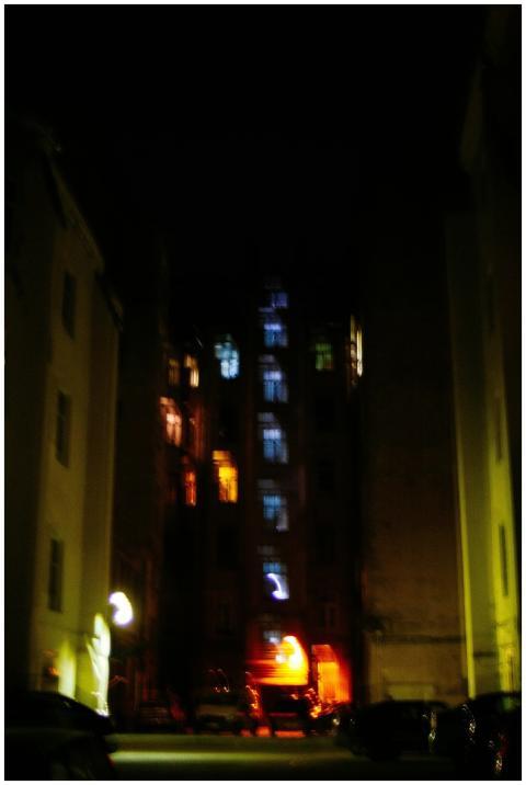 A dark and moody urban alleyway with dimly lit bui