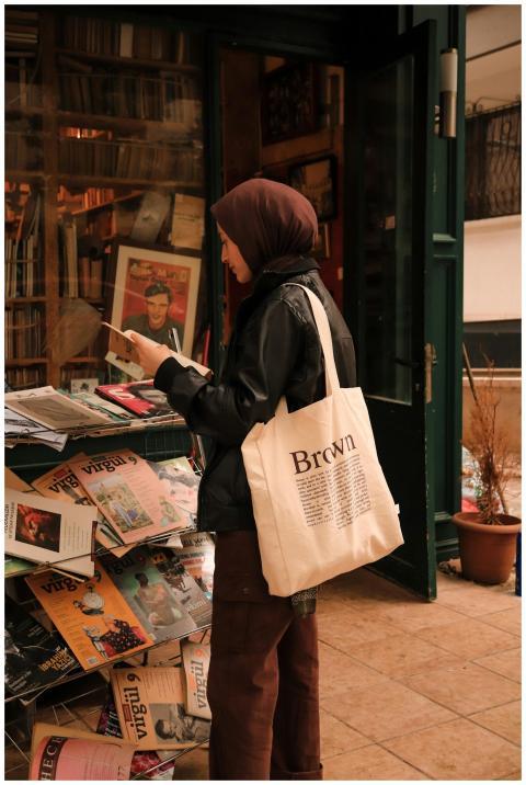 A woman in a hijab browsing magazines at a booksto