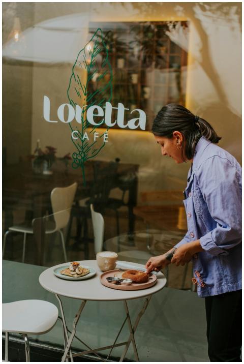 Woman setting breakfast table at an outdoor café w